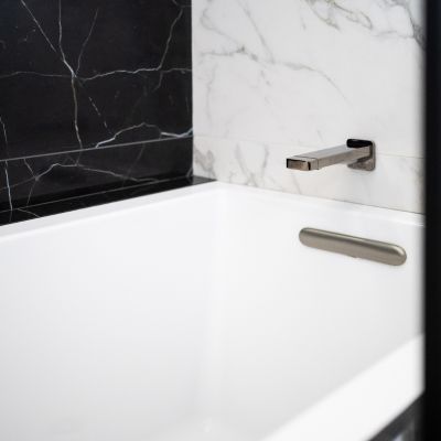 tub faucet with  black shower tile walls